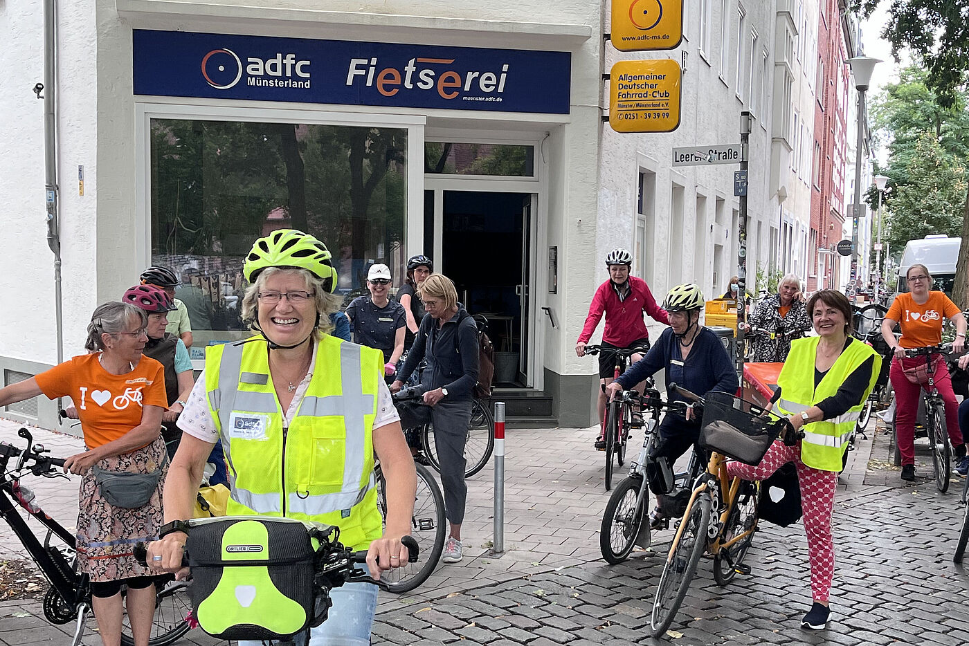 Frauen in Fahrradkleidung steigen auf ihre Fahrräder vor der Geschäftsstelle des ADFC Münsterland "Fietserei"