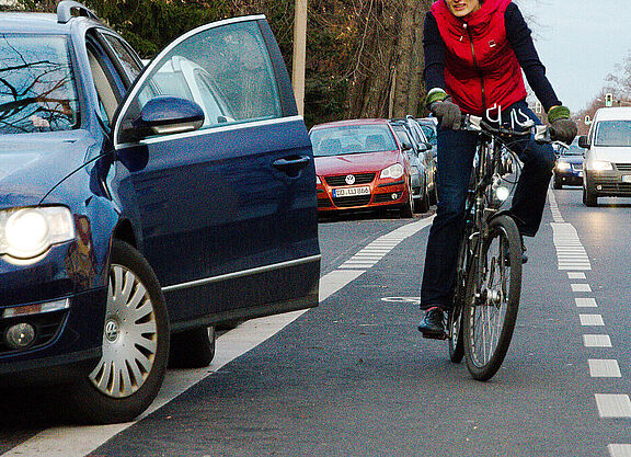 Dooring-Gefahr Auto Tür geöffnet, Radfahrerin weicht in Kfz Verkehr aus.