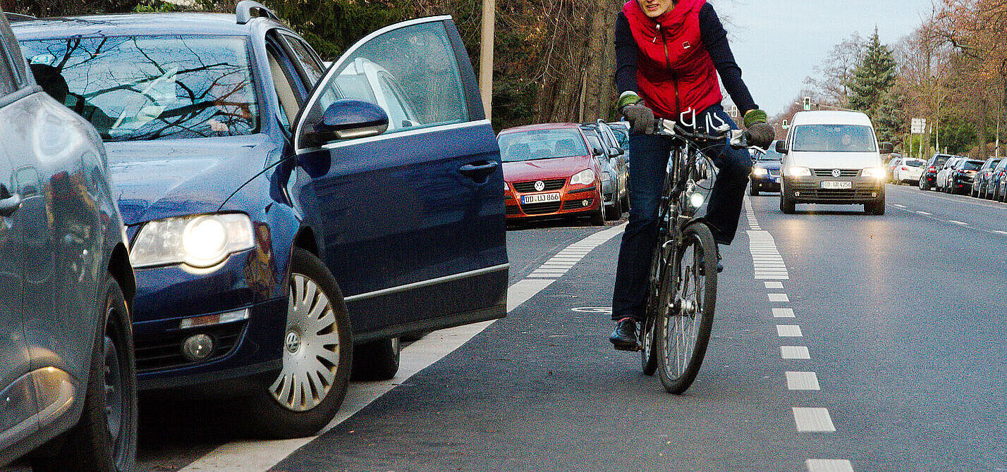 Dooring-Gefahr Auto Tür geöffnet, Radfahrerin weicht in Kfz Verkehr aus.