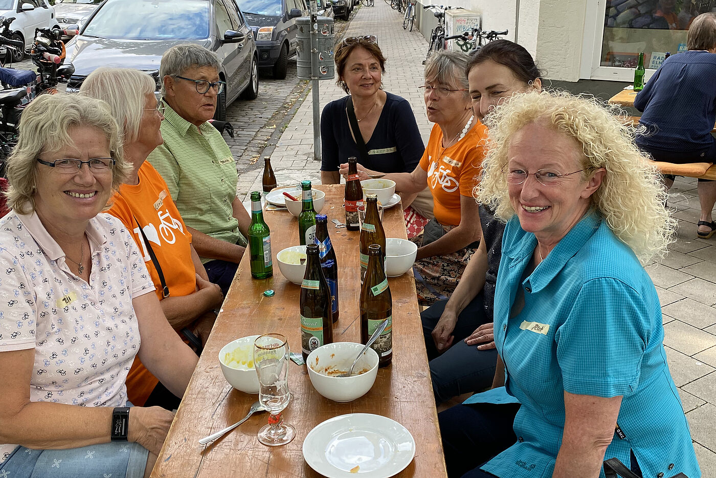 ADFC Frauen sitzen gut gelaunt bei Suppe und Bier am Biertisch vor der "Fietserei" des ADFC Münsterland