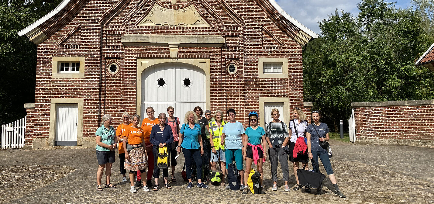 ADFC Frauennetzwerk NRW zu Gast im Haus Rüschhaus Radfahrerinnen in bunter Kleidung vor dem historischen Gebäude Haus Rüschhaus