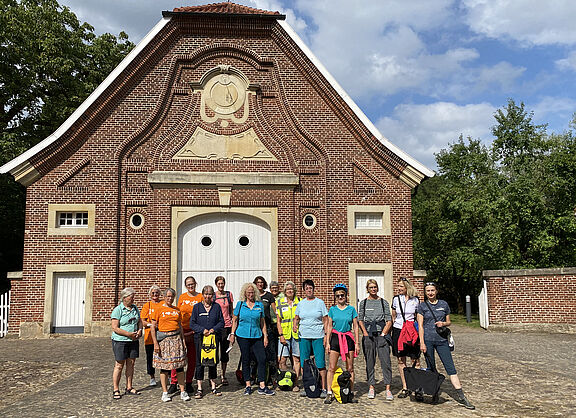 Radfahrerinnen in bunter Kleidung vor dem historischen Gebäude Haus Rüschhaus