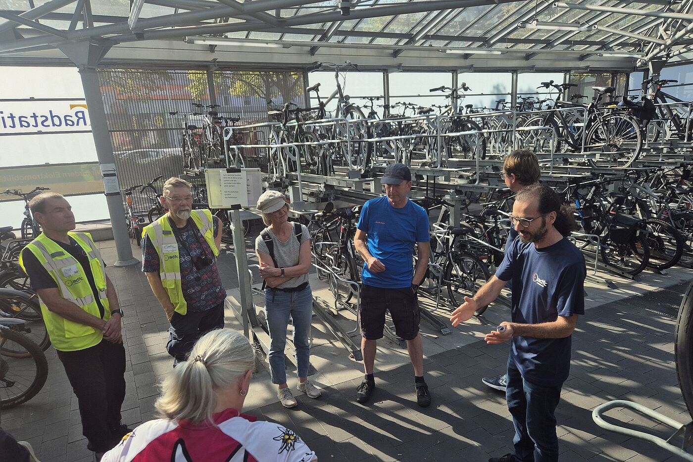 mehrere Menschen stehen in der Radstation. 