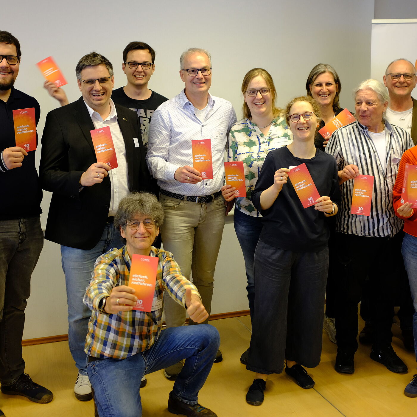 Der ADFC NRW Landesvorstand freut sich über den Kampagnenstart und hält den Flyer hoch. 