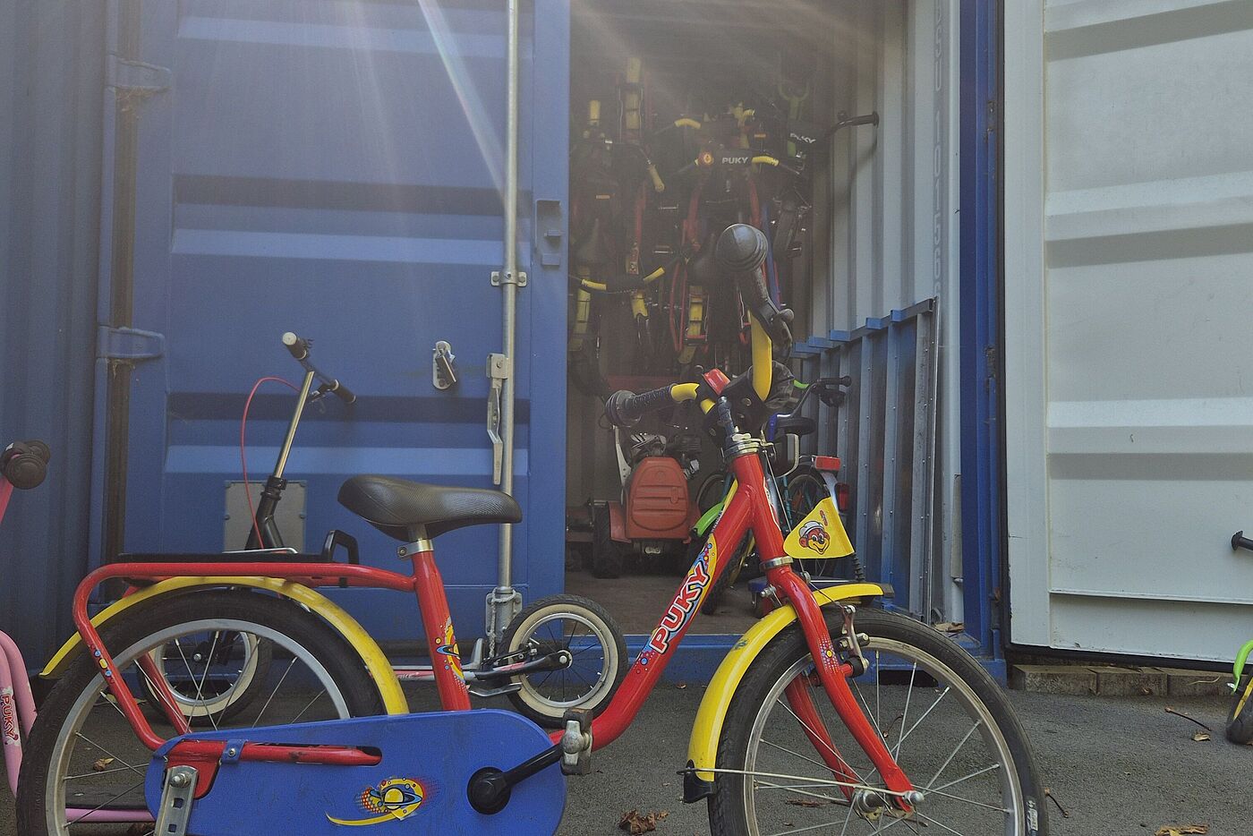Kleines Fahrrad vor Container. 